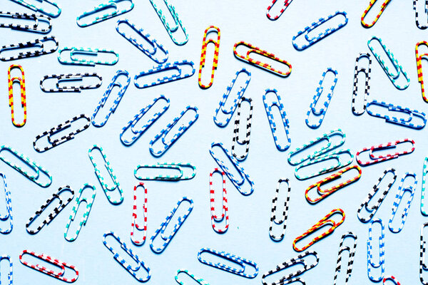 Красочные полосатые красивые скрепки для бумаги на голубом фоне
