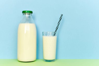Cam şişe ve saman ile şeffaf bir bardak süt 