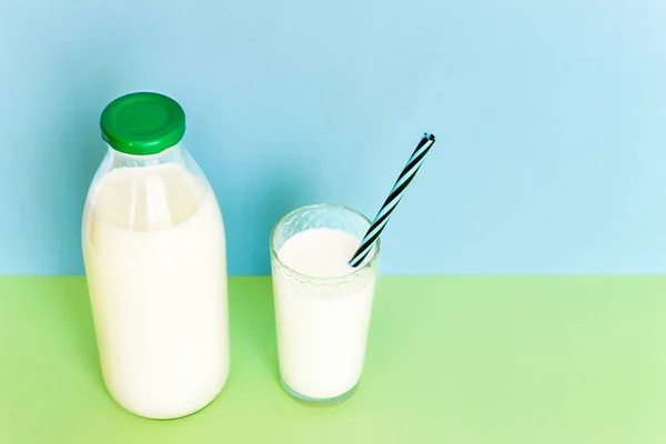 Melk in een glazen fles en een transparant glas met rietje — Stockfoto