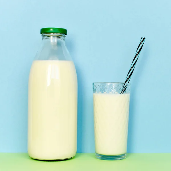 Lait dans une bouteille en verre et un verre transparent avec paille — Photo