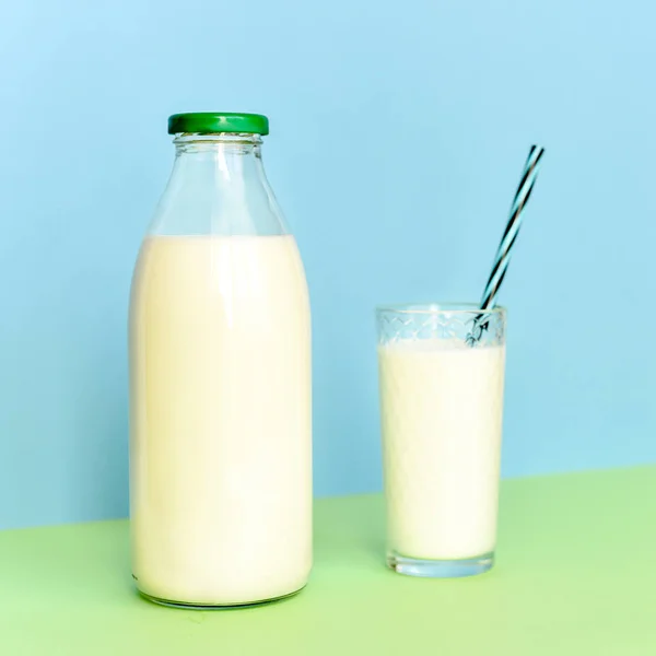 Milk in a glass bottle and a transparent glass with straw — Stock Photo, Image