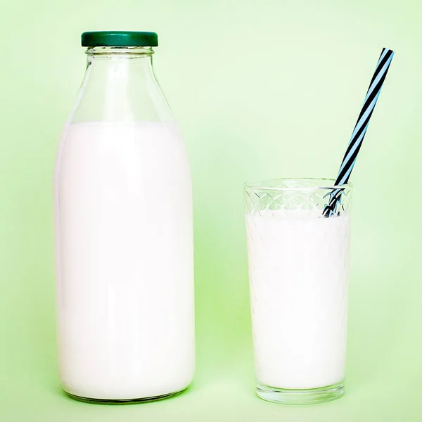 Milk in a glass bottle and a transparent glass with straw — Stock Photo, Image