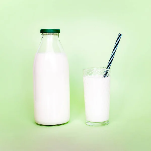Melk in een glazen fles en een transparant glas met rietje — Stockfoto