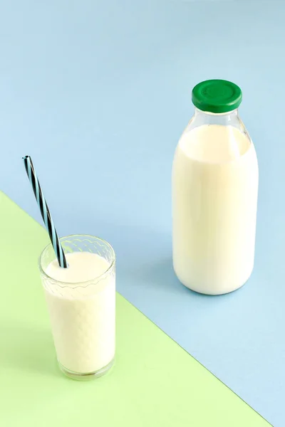Молоко в скляній пляшці і прозоре скло з соломою — стокове фото