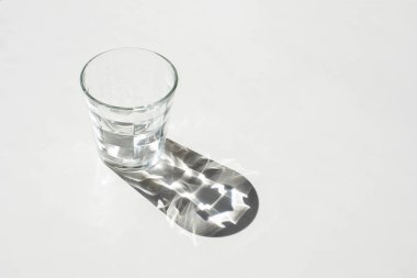 Siyah-beyaz fotoğraf üzerinde saydam bir cam bardak