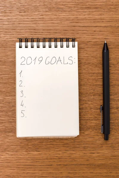 Notebook s cíle pro 2019 na dřevěný povrch — Stock fotografie