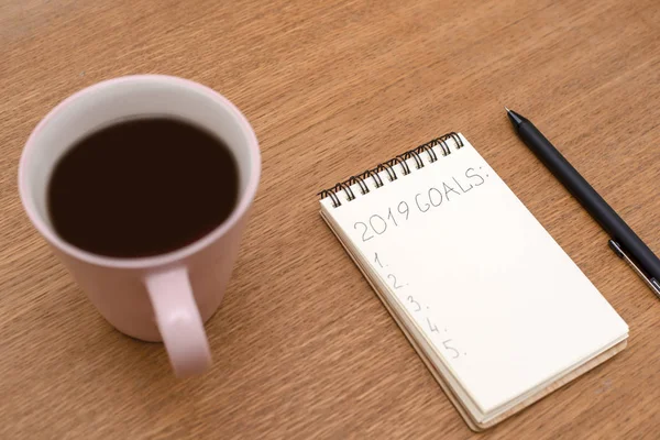 Caderno com inscrição Metas e xícara de café na madeira — Fotografia de Stock