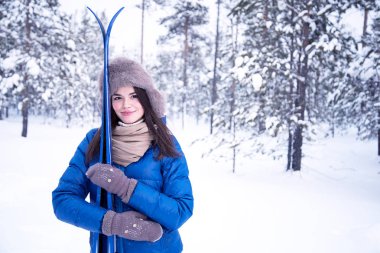 Beautiful girl is going skiing in the woods clipart