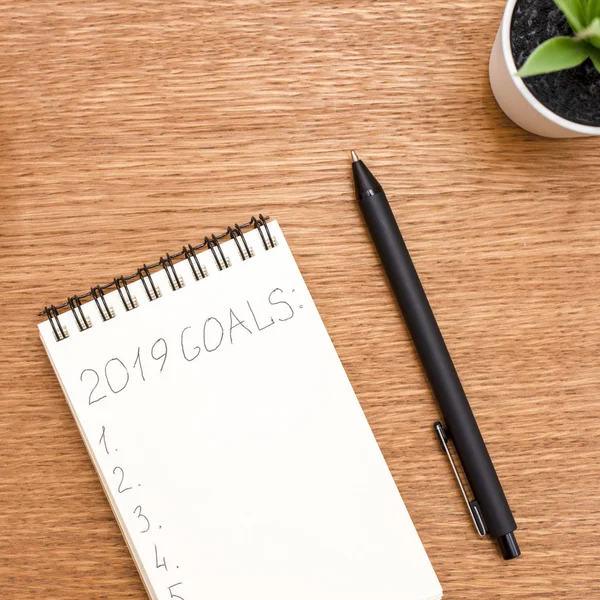Caderno com metas para 2019 em uma superfície de madeira — Fotografia de Stock