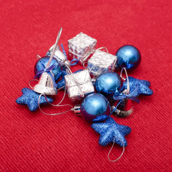 Χριστούγεννα παιχνίδια μπλε και ασημένια χρώματα σε φόντο κόκκινο πλεκτό ύφασμα — Φωτογραφία Αρχείου
