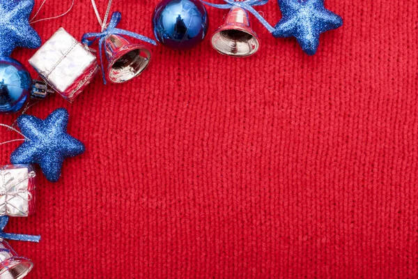 Επίπεδη lay από χριστουγεννιάτικα παιχνίδια μπλε και ασημί χρώμα σε κόκκινο φόντο — Φωτογραφία Αρχείου