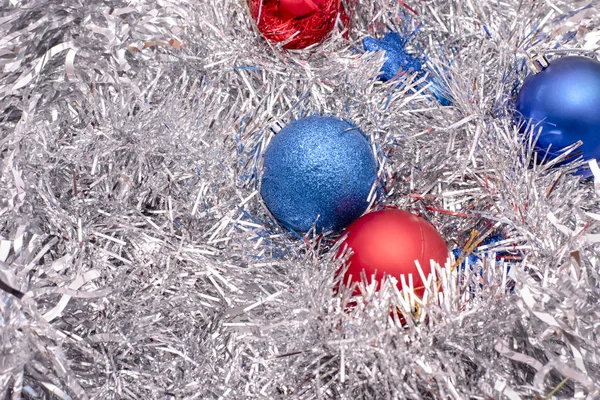 Beautiful Christmas toys of blue and red colors on tinsel Stock Image