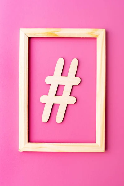 Hashtag sinal feito de material de madeira no quadro sobre fundo rosa — Fotografia de Stock