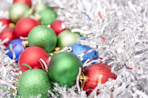 Χριστούγεννα παιχνίδια, πράσινο, μπλε και κόκκινα χρώματα στο φόντο των ασημένιες πούλιες — Φωτογραφία Αρχείου