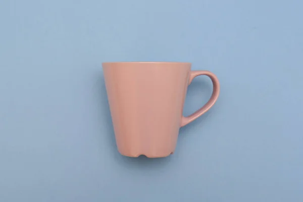 Belle tasse rose avec poignée sur fond bleu — Photo