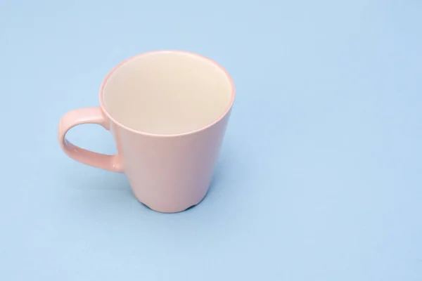 Belle tasse rose avec poignée sur fond bleu — Photo