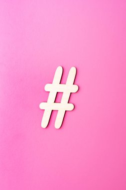 Pembe bir arka plan üzerinde ahşap malzemeden yapılmış Hashtag işareti