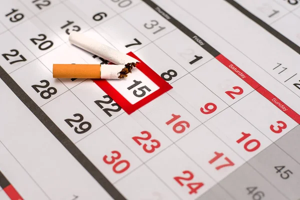 カレンダー、日付が強調表示されますと、壊れたタバコ、禁煙、新しい人生の始まりの日を象徴します。 — ストック写真