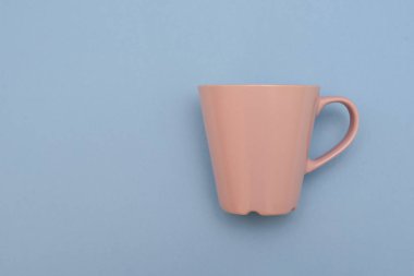 Pembe güzel kupa ile mavi arka plan üzerindeki kolu