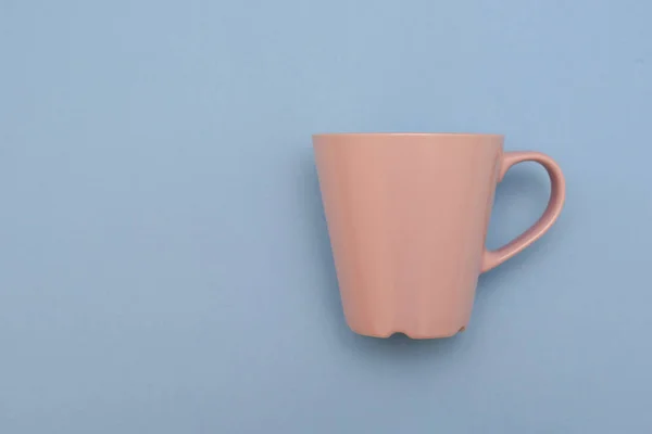 Belle tasse rose avec poignée sur fond bleu — Photo