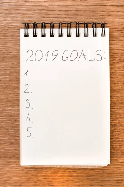 Notebook with goals for 2019 on a wooden surface — Stock Photo, Image