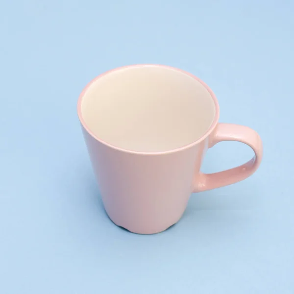 Belle tasse rose avec poignée sur fond bleu — Photo