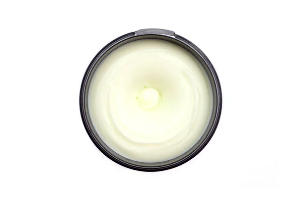 Crema corporal y facial de color blanco verdoso en un paquete redondo, vista superior, aislado en blanco — Foto de Stock