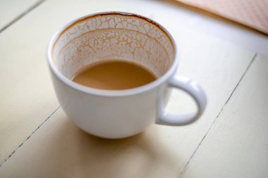 Yarısı boş beyaz kahve fincanı ahşap tablo