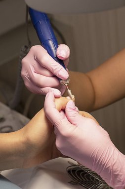 Belgili tanımlık tırnak salonu istemci manikürcü pembe eldiven vernik manikür aygıtla kaldırır