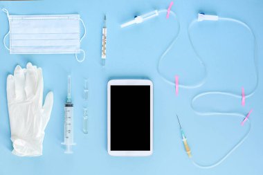 Çeşitli tıbbi malzeme ve tablet üzerinde mavi arka plan