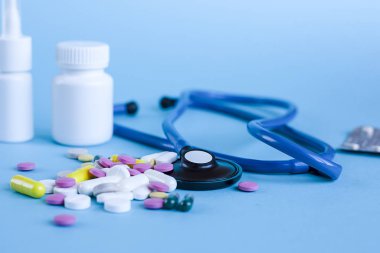 Çok renkli hap, kapsül ve mavi stetoskop