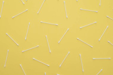 Sarı zemin üzerine beyaz pamuklu bezlerden rasgele sırada yalan.