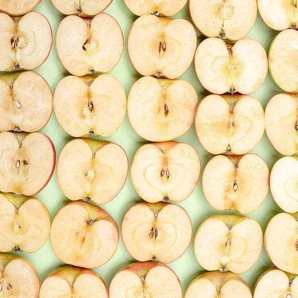 Υπόβαθρο της κομμένα σε μισά μήλα σε πράσινο φόντο — Φωτογραφία Αρχείου