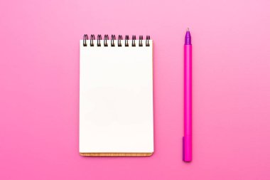 Boş defter etiketleri ve kalem uygulanması için Helisel pembe bir arka plan ile