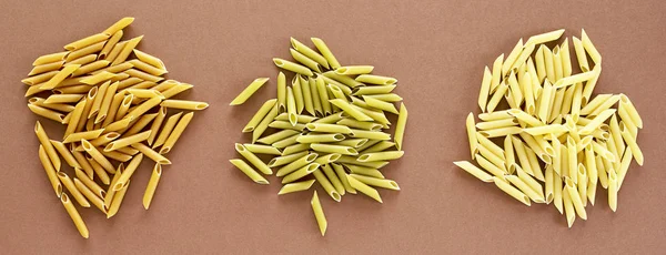 Diferentes pastas en forma de tubos de color marrón, amarillo y verde —  Fotos de Stock