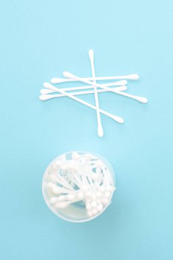 Bir kavanoz mavi bir arka plan üzerinde beyaz pamuk temizleme bezi vardır. Hijyen araçları.