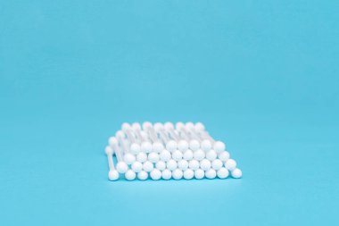 Mavi arka planda beyaz pamuklu tomurcuklar birbirlerine yalan