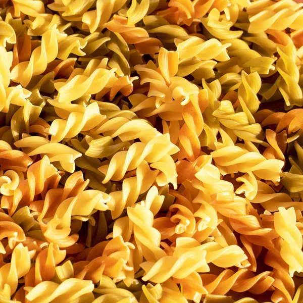 Diferentes pastas en forma de espirales de colores marrón, amarillo y verde —  Fotos de Stock