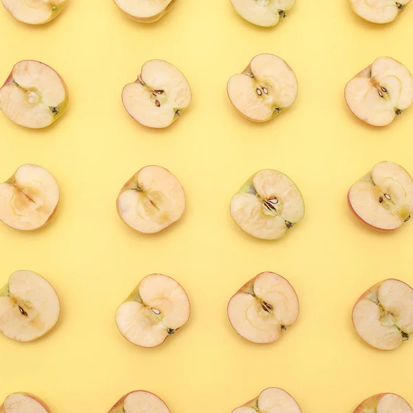 Fondo de corte en medio manzanas sobre fondo amarillo — Foto de Stock