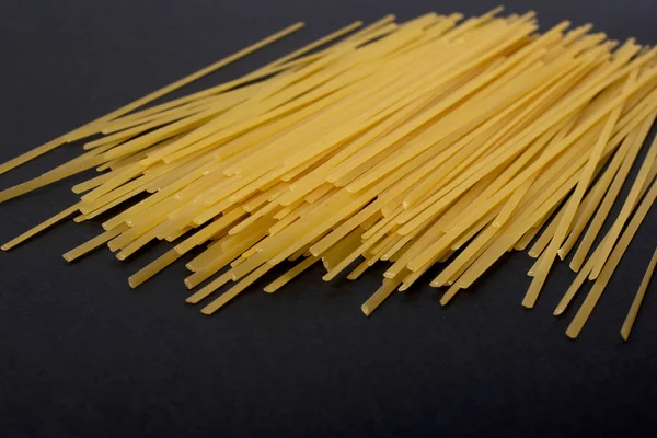 Flache Spaghetti auf schwarzem Hintergrund — Stockfoto