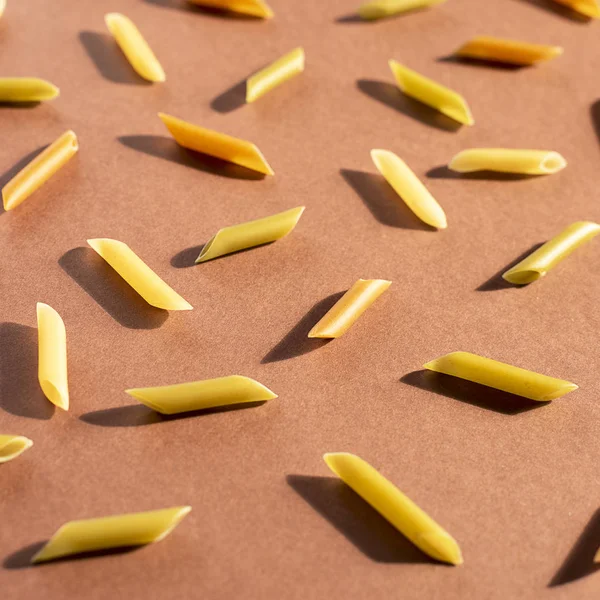 Різні макарони у вигляді трубок коричневого, жовтого та зеленого кольорів — стокове фото