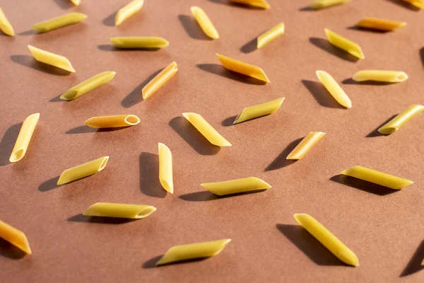 Різні макарони у вигляді трубок коричневого, жовтого та зеленого кольорів — стокове фото