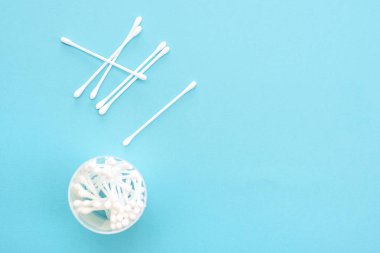 Bir kavanoz mavi bir arka plan üzerinde beyaz pamuk temizleme bezi vardır. Hijyen araçları.