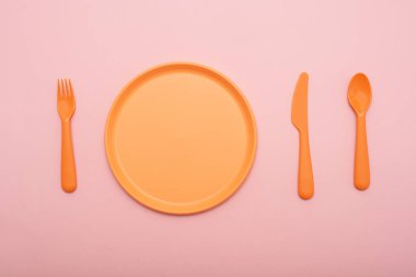 Turuncu yemek seti pembe arka plan üzerinde