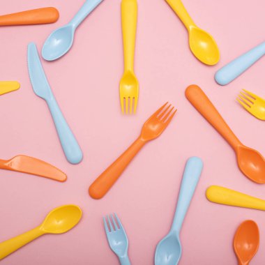 Renkli sofra : kaşık, bıçak, pembe arka plan üzerinde çatal. Üstte görüntü.