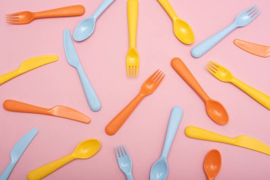 Renkli sofra : kaşık, bıçak, pembe arka plan üzerinde çatal. Üstte görüntü.