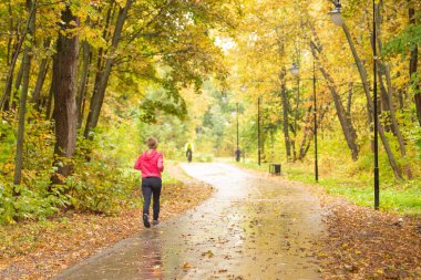 Sonbaharda yürüyen insanlarla şehir parkı