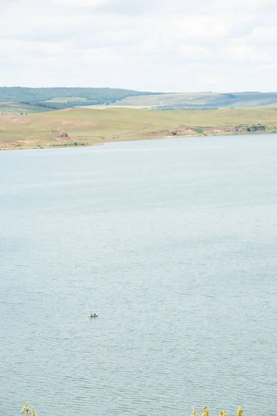 A fisherman is fishing in the lake on a clear summer day. Fishing. Hobby. Weekend. Rest.