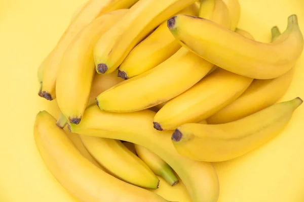 Yellow bananas on a yellow background. Fresh delicious flavored natural bananas. Natural product. Diet.