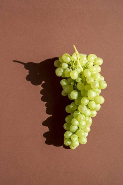 Kahverengi arka planda üzümler. Bir sürü. Doğal güneş ışığı.